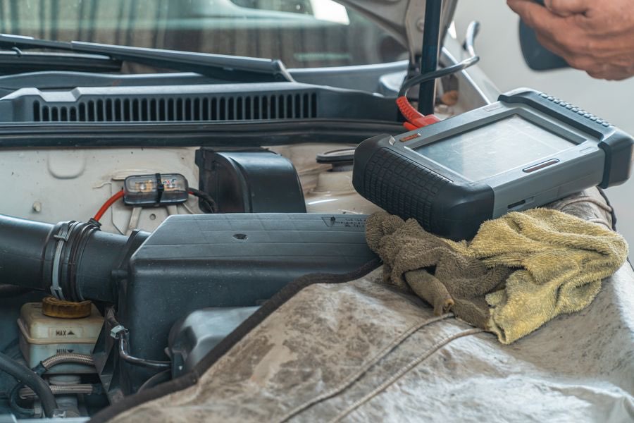 Diagnostic scan tool resting on a car engine bay