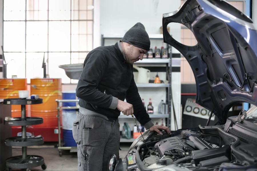 Mechanic working under the open hood of a car